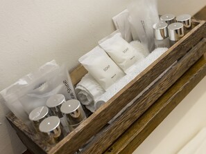 A wooden tray with toiletries including soap, a toothbrush, and a towel.