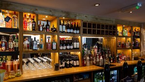 A bar with shelves of various liquor bottles and glasses.
