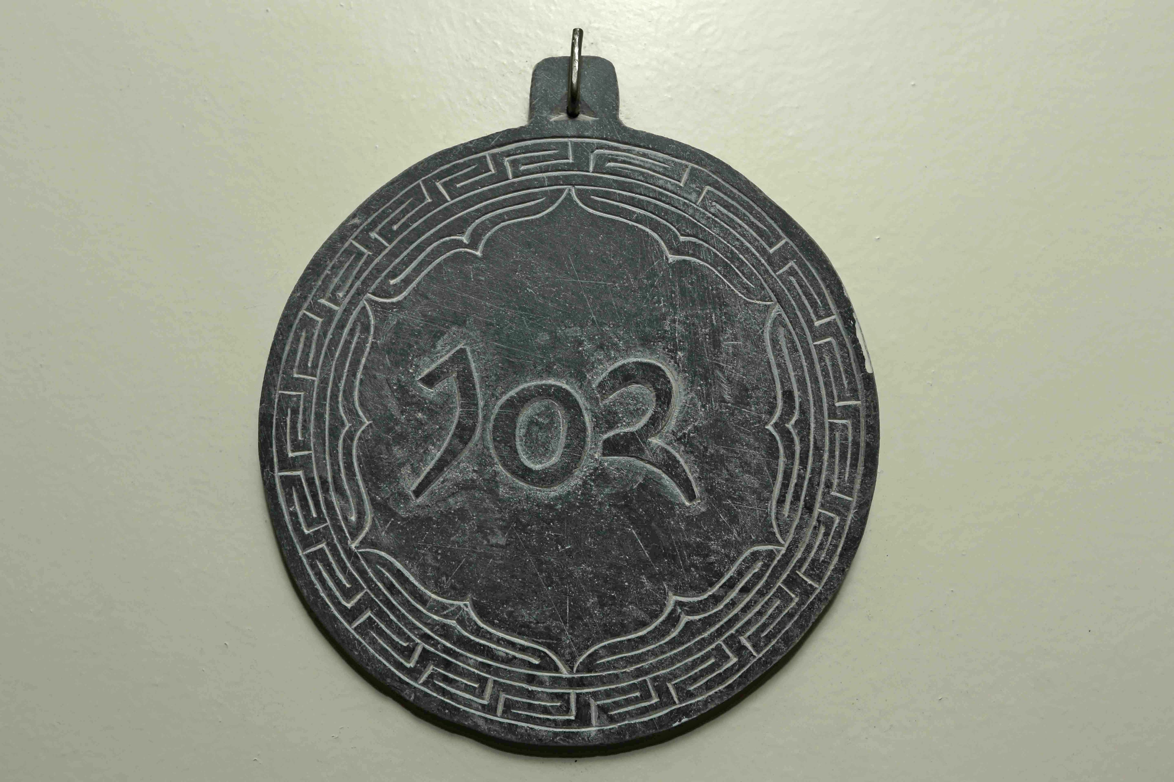 A circular object with the number 102 engraved on it.