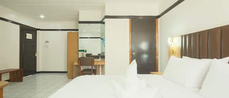 A hotel room with a bed, a desk, and a chair.