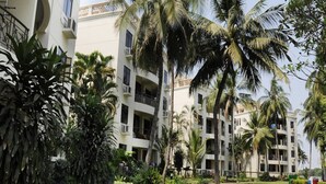 A multi-story hotel with balconies, surrounded by lush greenery and palm trees. - Riverside Serviced Apartments (Ho Chi Minh City)