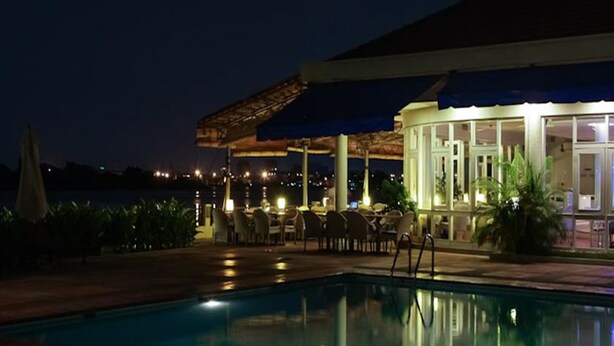 A nighttime poolside area with a covered seating area and a pool. - Riverside Serviced Apartments (Ho Chi Minh City)