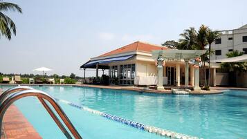 Una piscina al aire libre, sillones reclinables de piscina