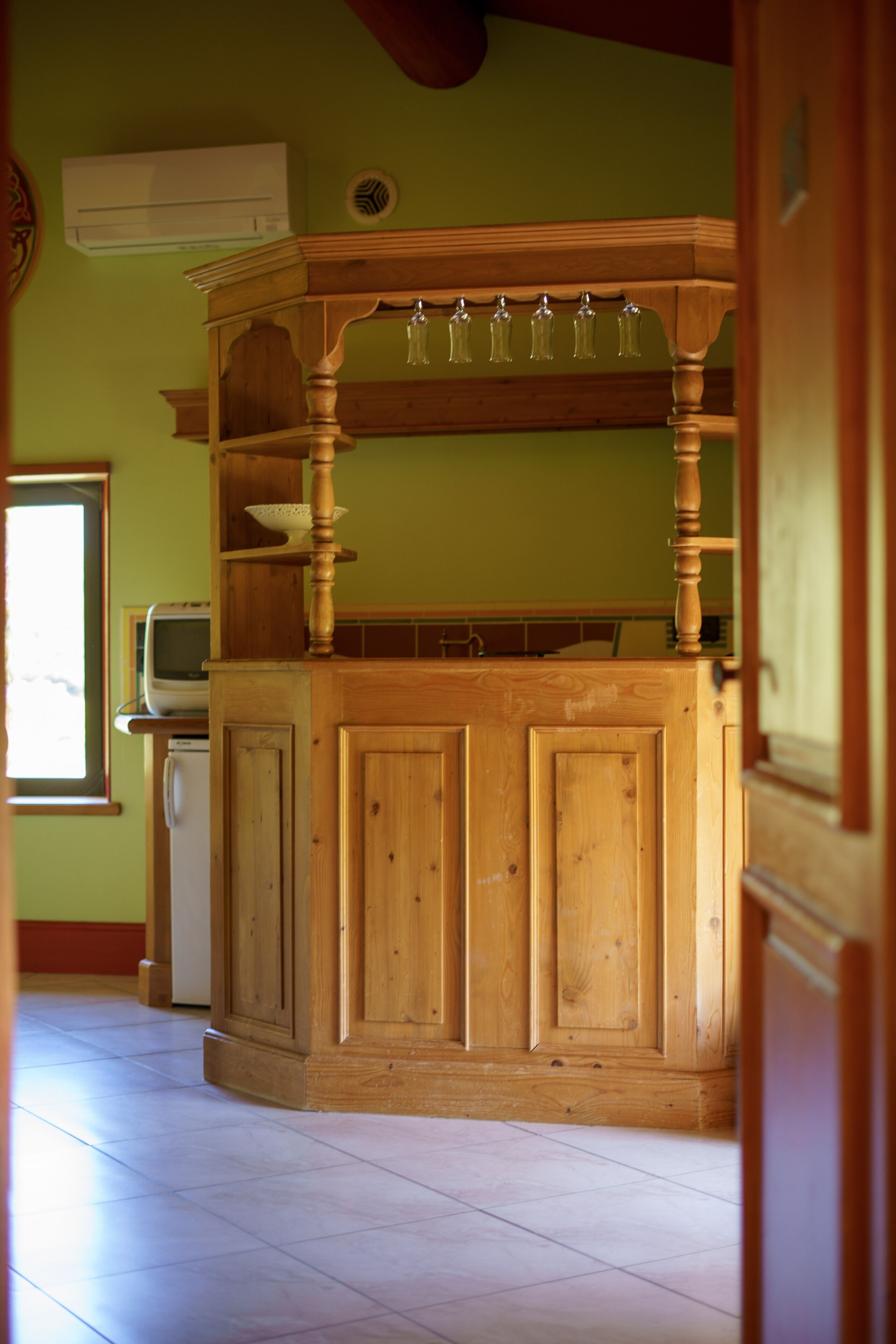 Un área con barra de madera, un lavamanos integrado y una ventana.
