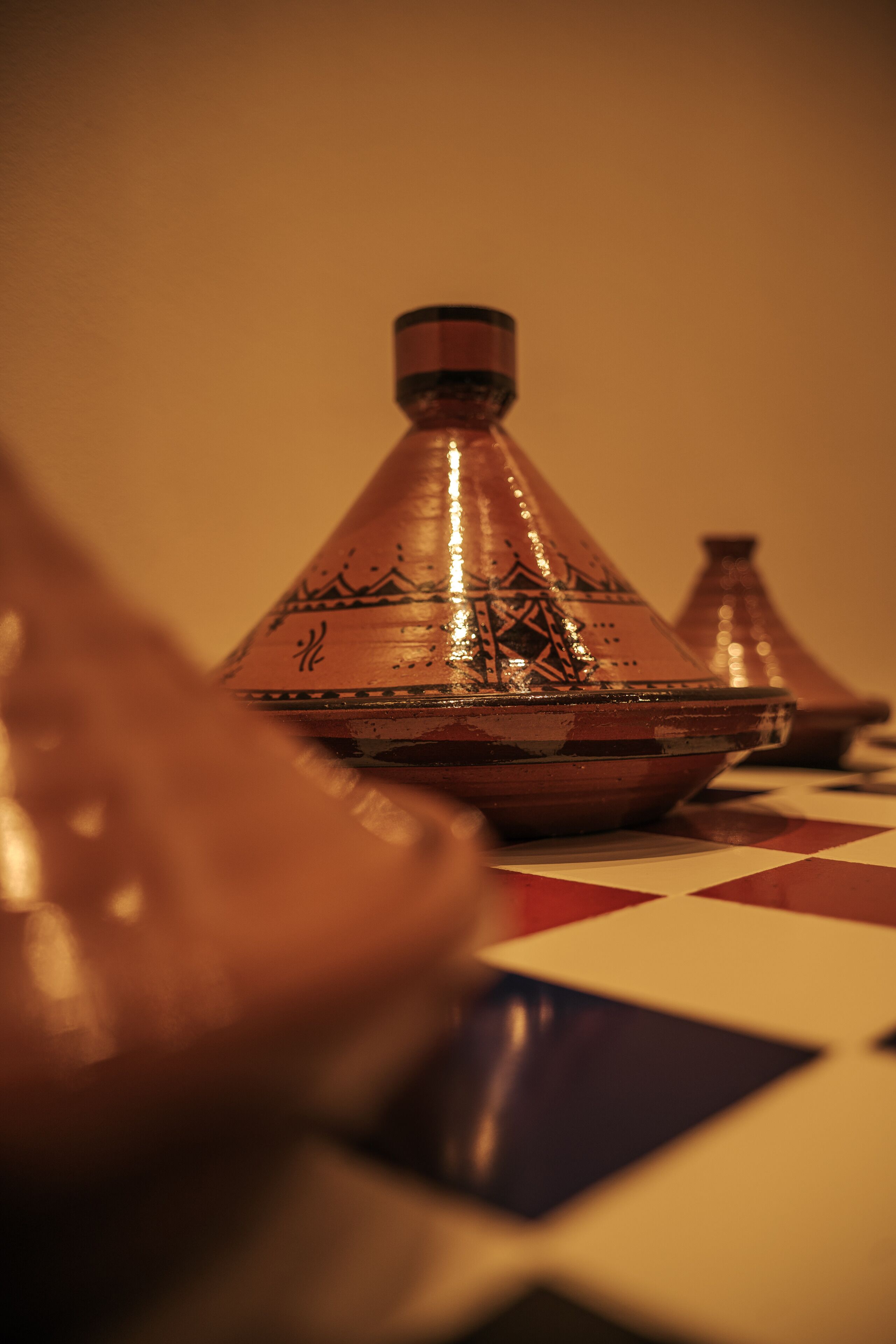 Primer plano de una tagine marroquí tradicional sobre un mantel a cuadros.