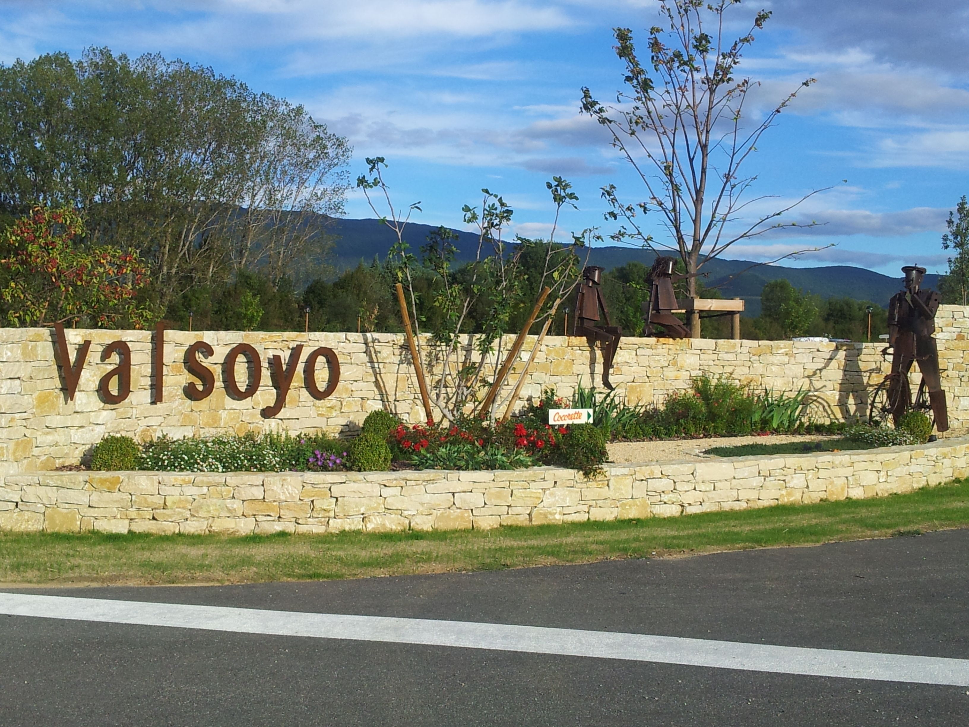 Un muro de piedra con el nombre 'Valsoyo' y un letrero que indica 'Cocacola'.