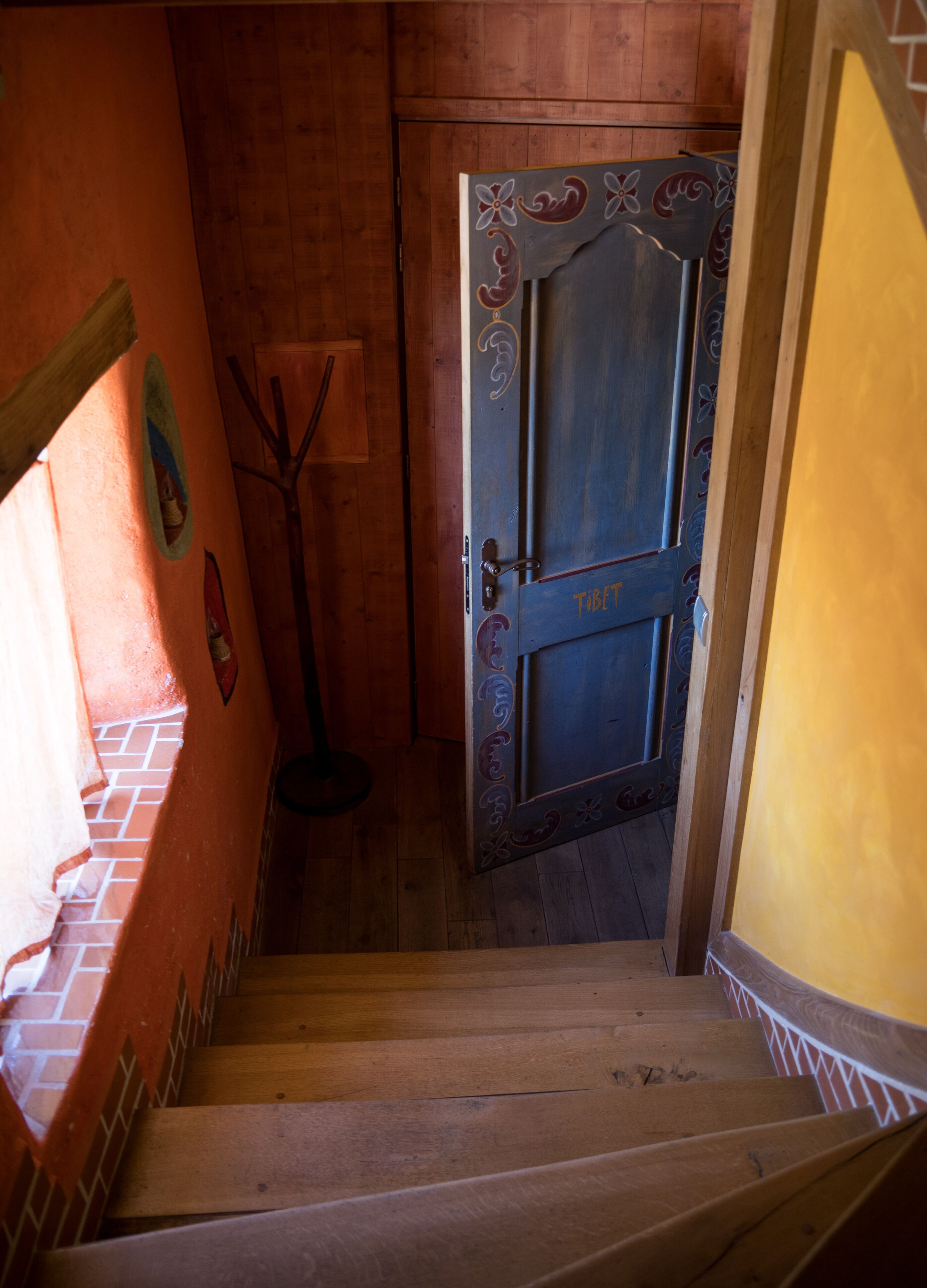A wooden staircase leading to a door with Tibetan script.