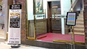 Un bâtiment sur lequel on peut lire l’inscription « FUNSTAY » et qui possède un escalier menant à l’entrée.