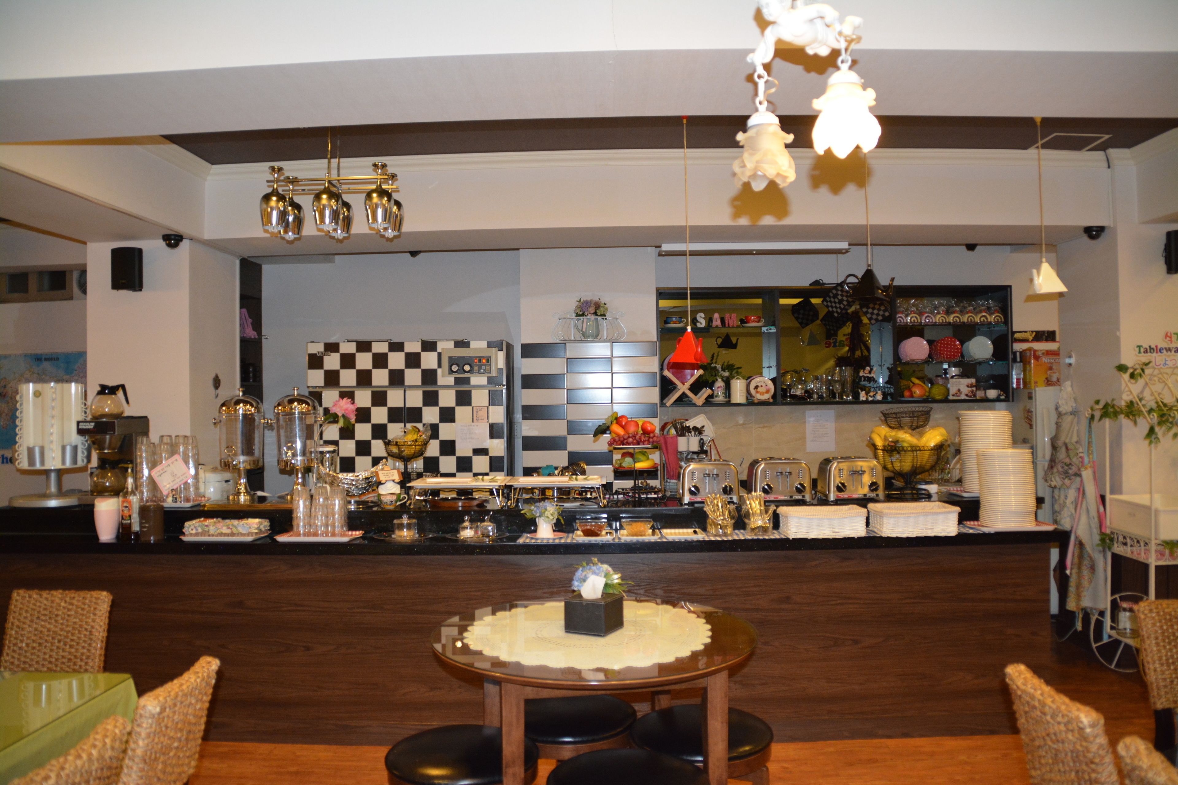 A restaurant with a checkered wall, a bar area, and a dining section with a round table and chairs.