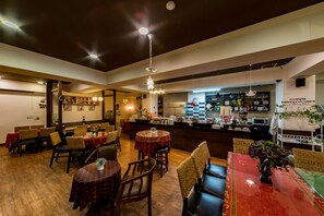 A restaurant interior with multiple dining tables, chairs, and a bar area. - FunStay Inn Guesthouse (Busan)