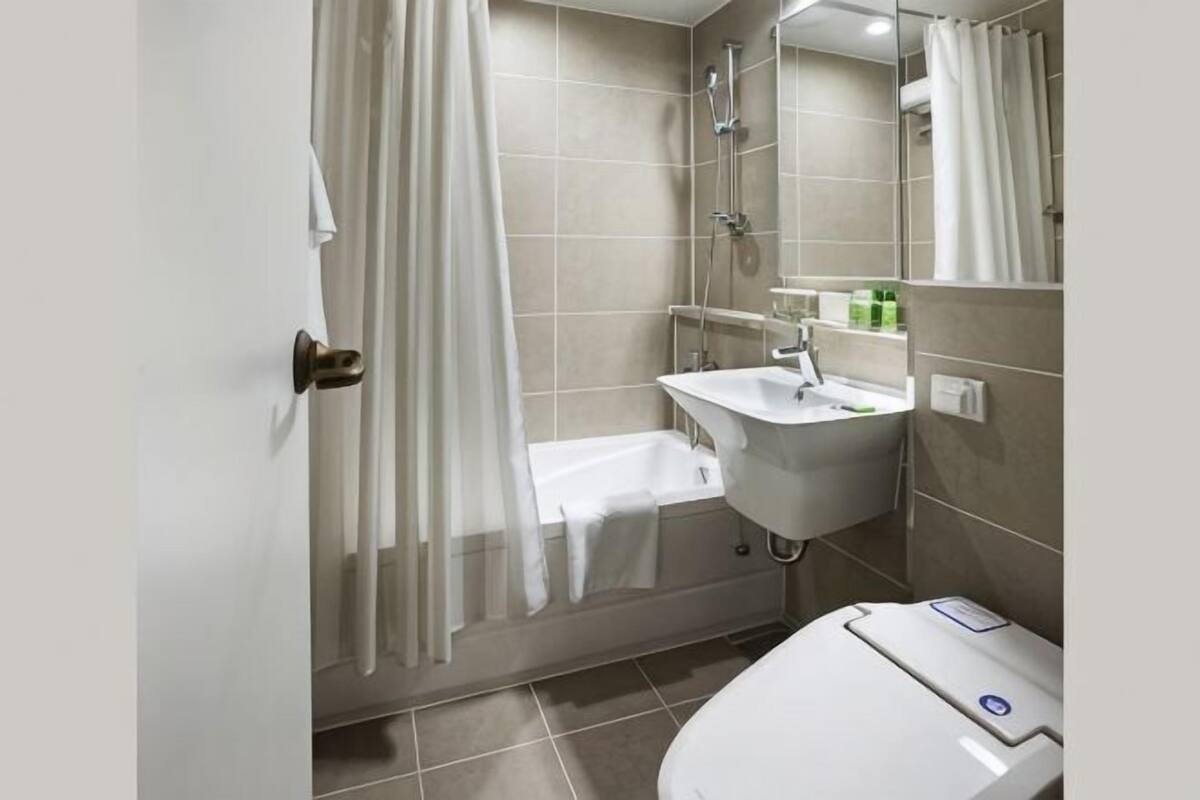 A bathroom with a shower, a sink, and a toilet.