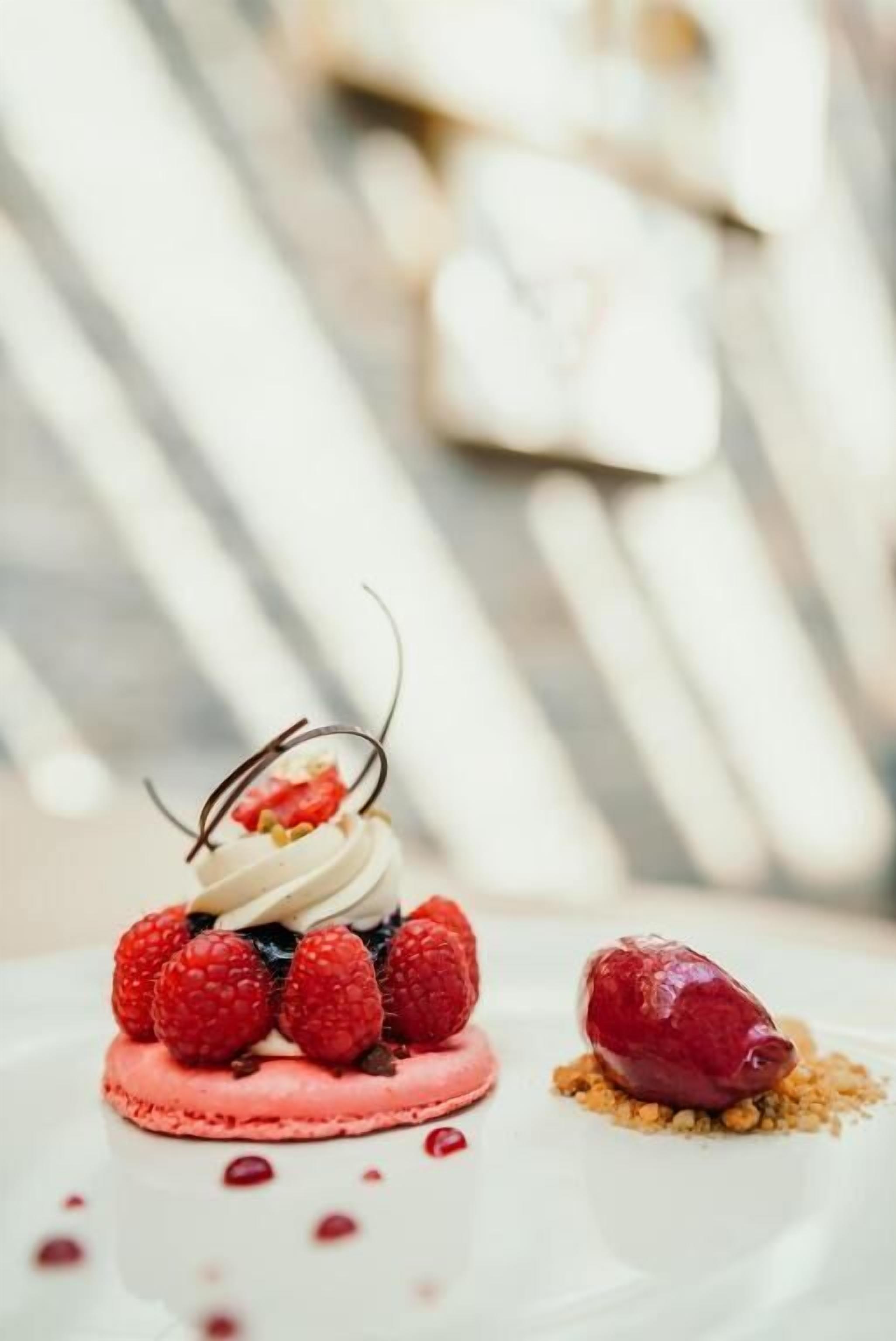 A dessert with raspberries and chocolate on a white plate.