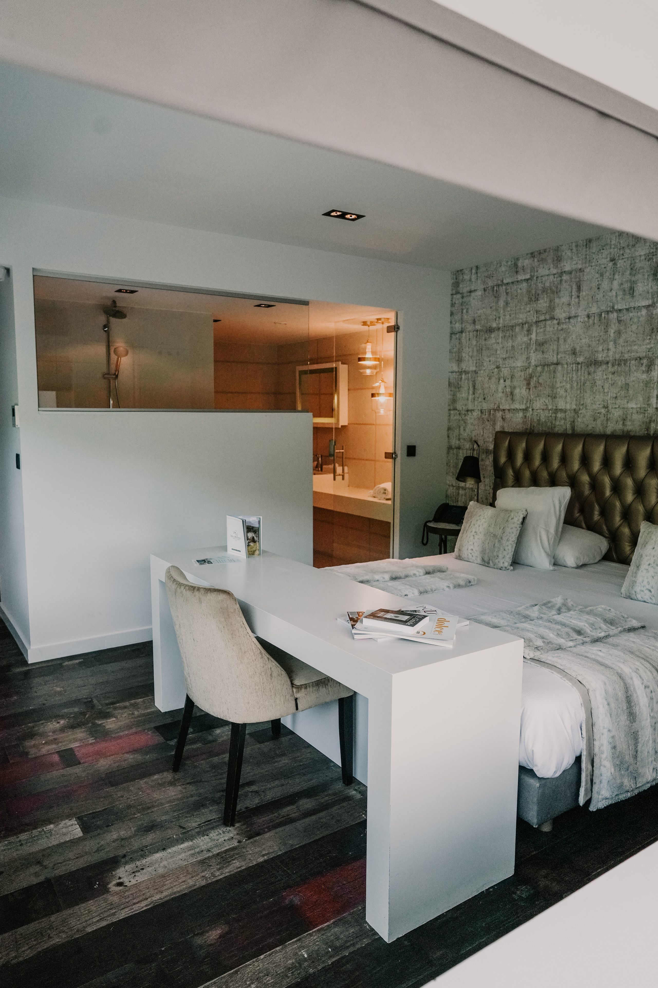 Une chambre d’hôtel moderne, dotée d’un grand lit, d’un bureau et d’une chaise.