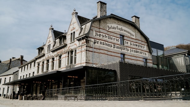 Un edificio histórico con un letrero que indica que es un restaurante y una banqueta.