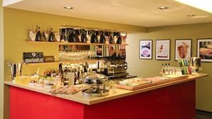Una zona de bar con una variedad de botellas, copas y una mesa de buffet.