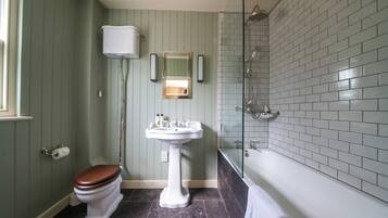 Een badkamer met toilet, wastafel en douche.