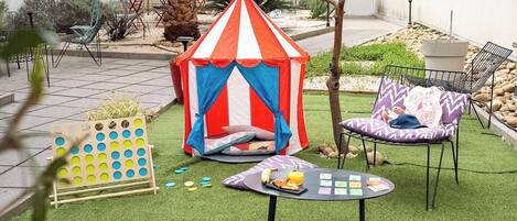 A tent, a table with food, and chairs in an outdoor area.