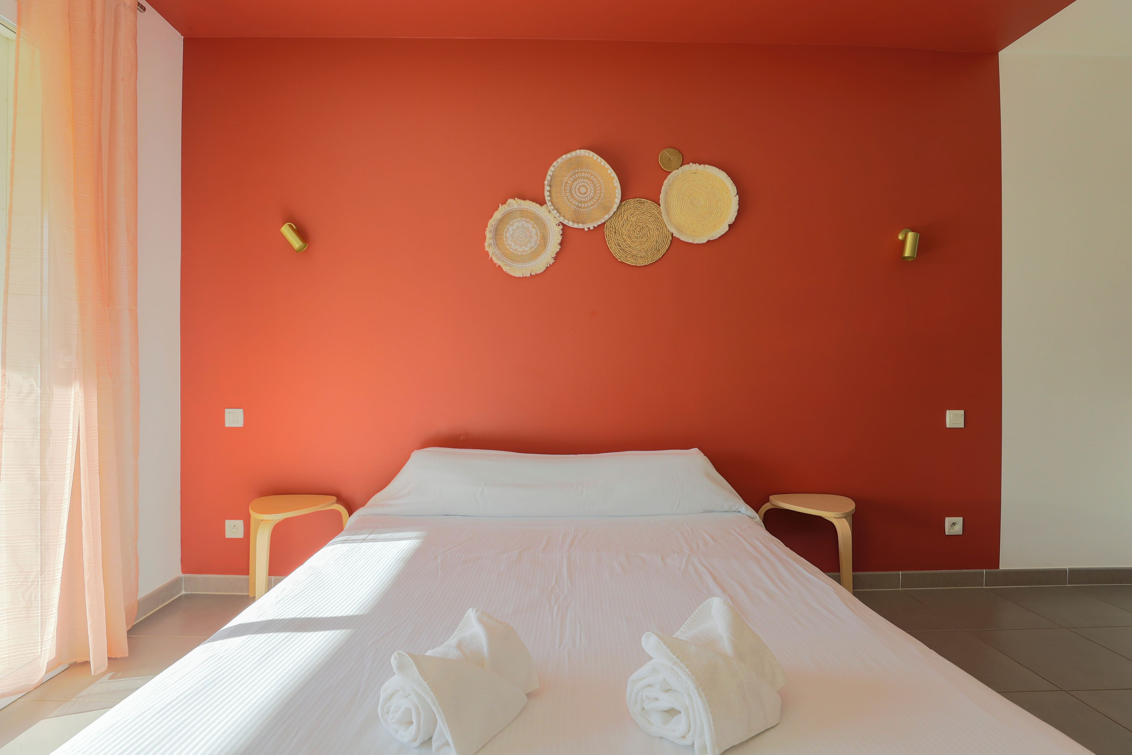 Ett hotellrum med en säng, två sidobord och en vägg med dekorativ väggkonst.