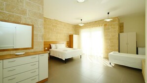 A bedroom with a bed, a bedside table, a wardrobe, and a mirror.