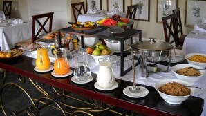 A breakfast buffet with various food items, a fruit bowl, and a coffee station. - Redlands Hotel (Pietermaritzburg)
