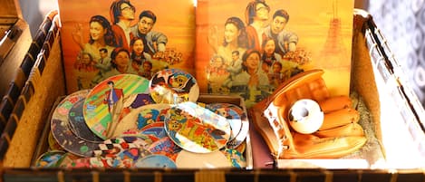 A wicker basket filled with various items including a book, colorful plates, and a pair of shoes.