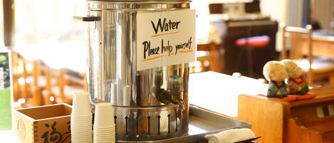 A water dispenser with a sign that reads "Water Please help yourself."