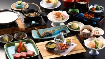A variety of Japanese dishes arranged on a table, including sushi, sashimi, and other traditional foods.