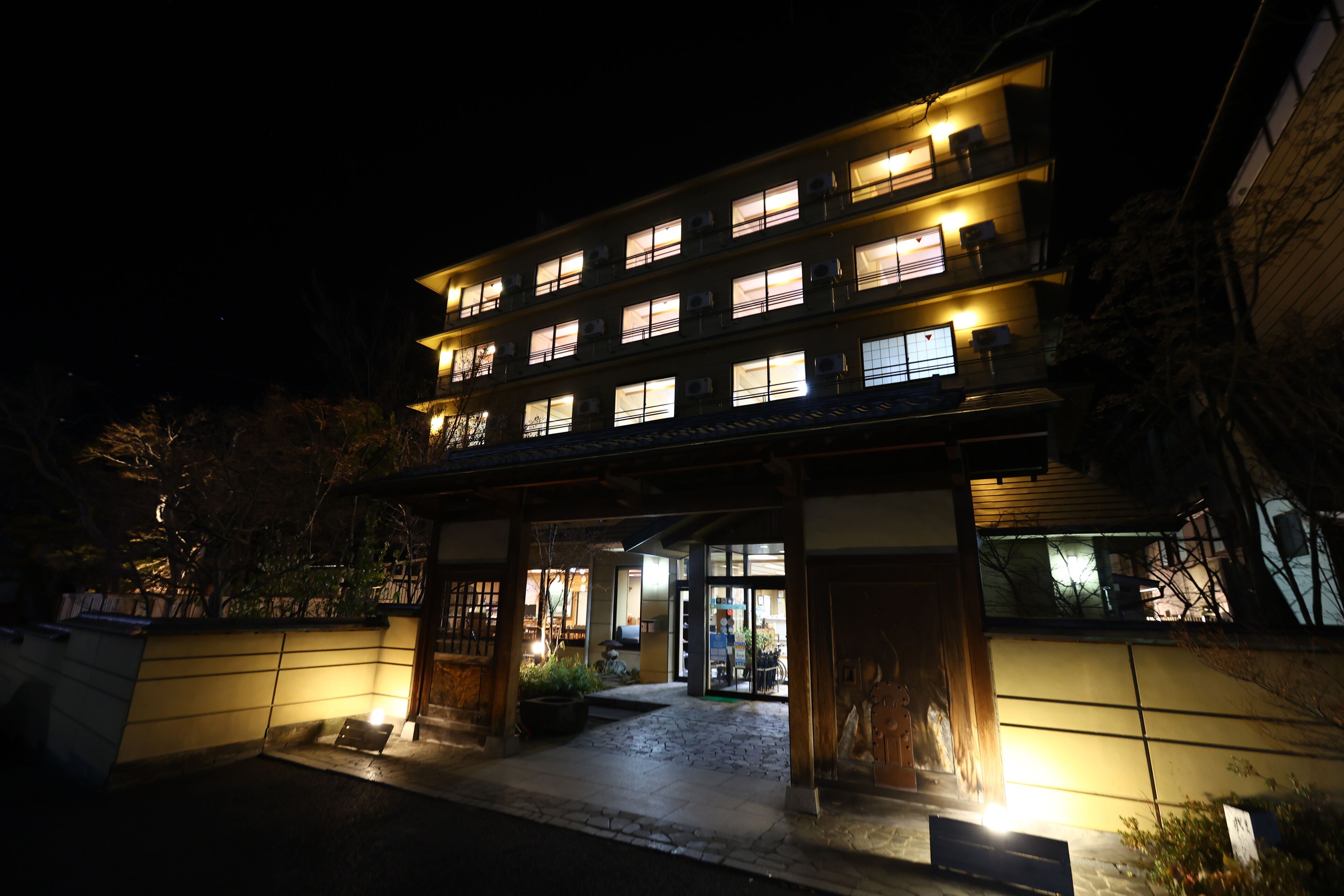 A multi-story hotel with illuminated windows and a well-lit entrance.