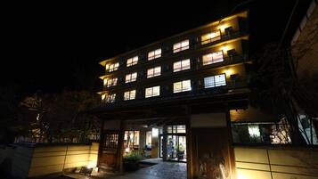 A multi-story hotel with illuminated windows and a well-lit entrance.