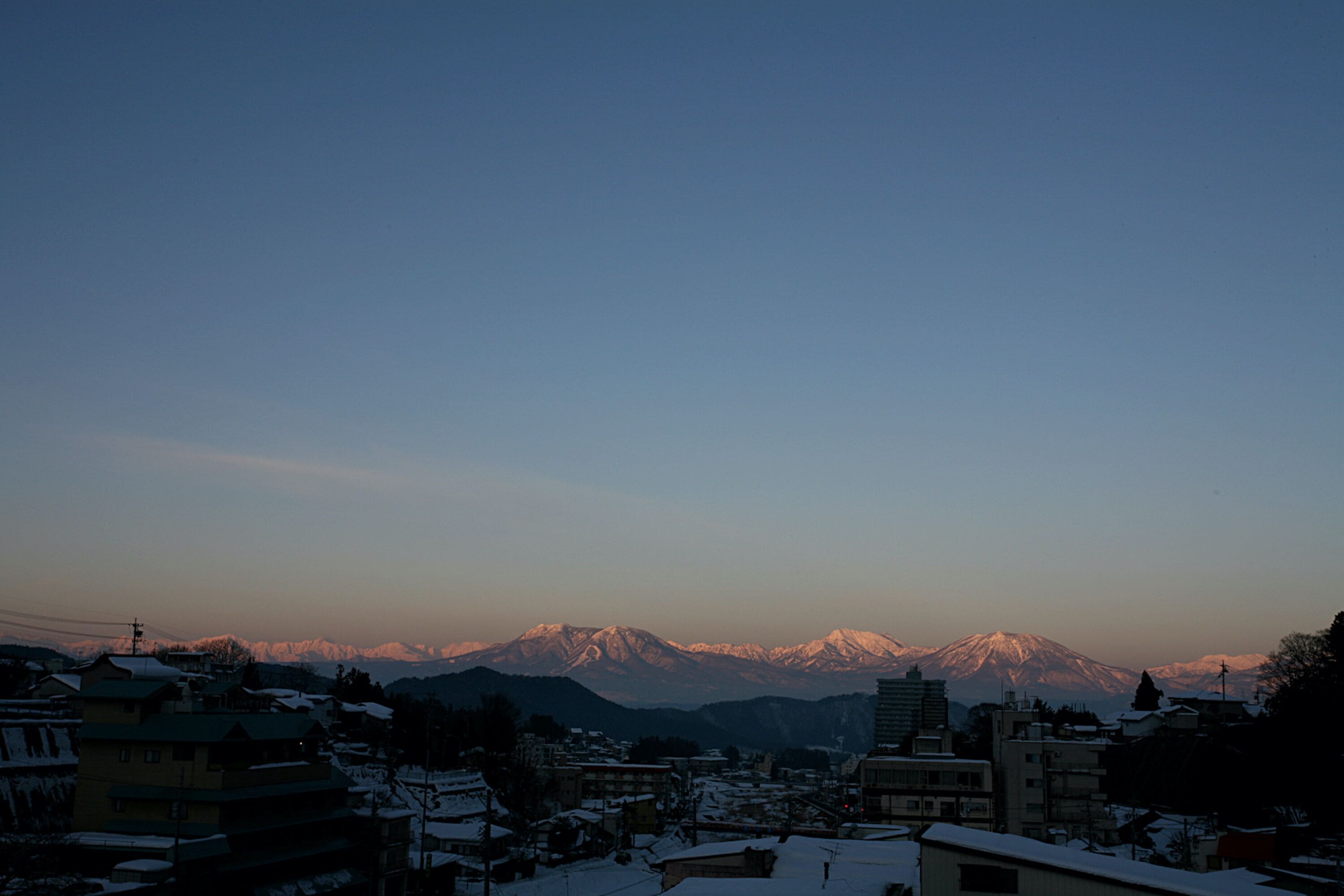 A town with buildings and a mountain range in the background.