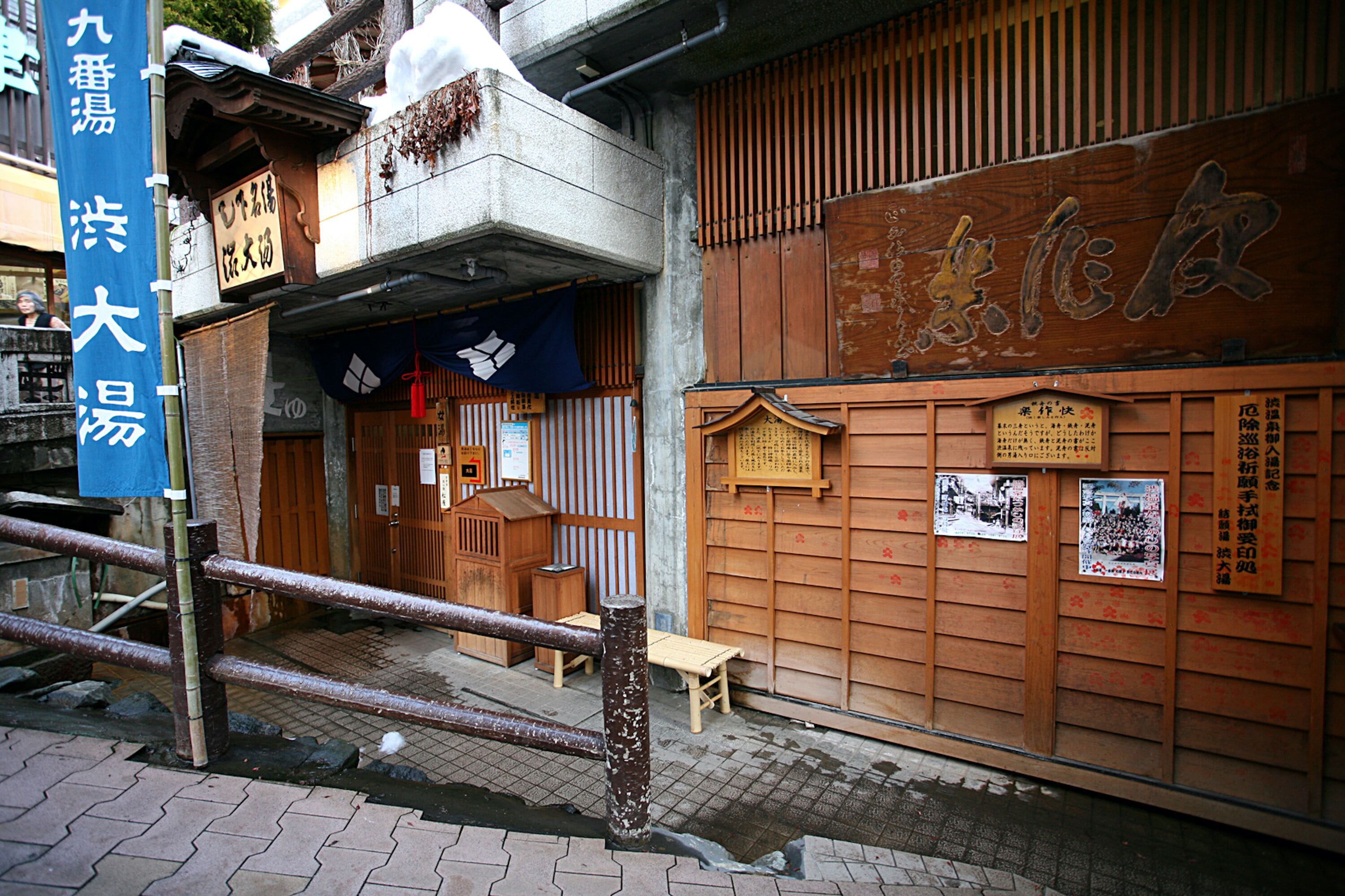 Ein traditionelles japanisches Gebäude mit Holzschiebetüren und einem Schild.