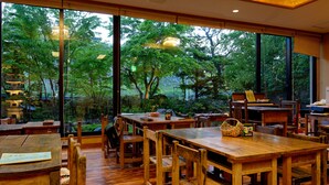 A traditional wooden interior with large windows overlooking a lush garden. - Shibu Hotel (Yamanouchi)
