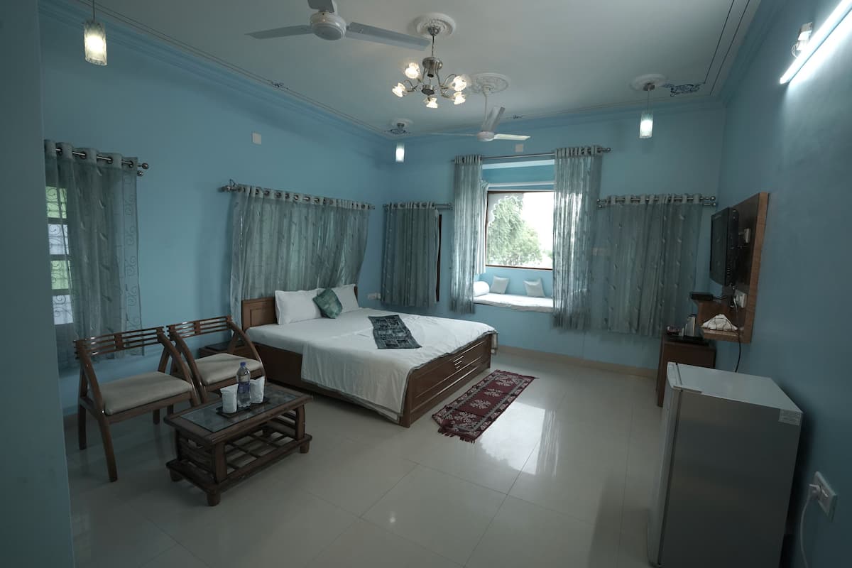 A bedroom with a bed, wooden furniture, a ceiling fan, and a window with curtains.