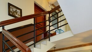 A multi-level staircase with wooden handrails and black metal railings, leading to different floors.