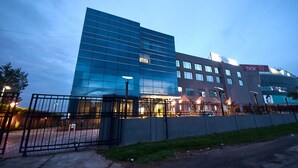 A modern building with a glass facade, a gated entrance, and signage for 'Golden' and 'Evok'.