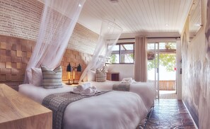 A hotel room with two beds, a wooden headboard, a canopy, and a view of the outdoors. - LIONSROCK Big Cat Sanctuary (Bethlehem)