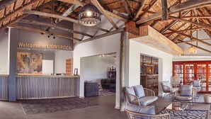 A reception area with a wooden ceiling, a reception desk, and a large tiger painting.