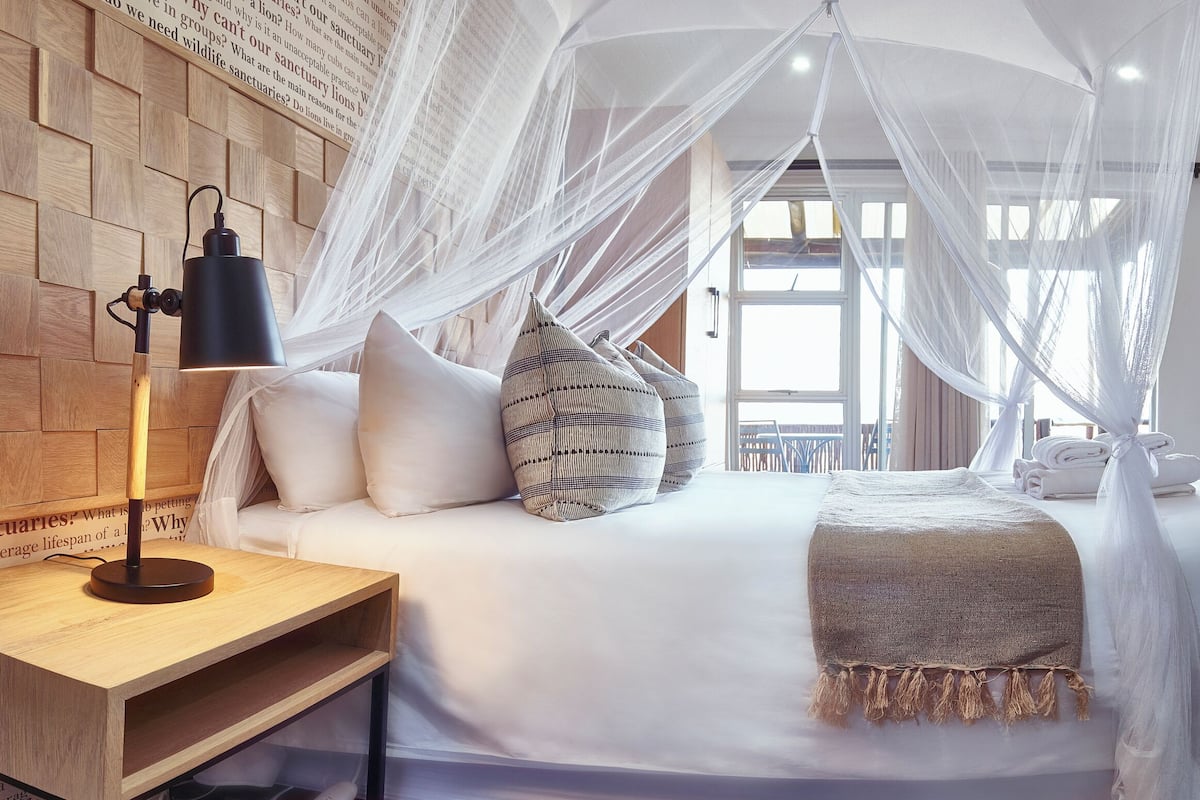 Une chambre à coucher avec un lit, une table de chevet, un bureau et une chaise.