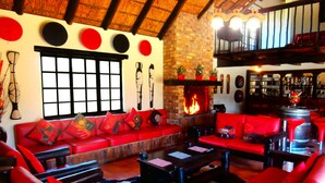 Una sala de estar acogedora con sofás rojos, una chimenea y una pared de ladrillo.