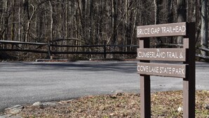 En träskylt med vägvisning till starten av vandringsleden Bruce Gap Trail, Cumberland Trail och delstatsparken Cove Lake.