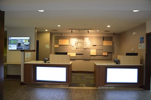 A hotel reception area with a digital display, reception desks, and a wall-mounted sign. - Holiday Inn Express & Suites, Caryville by IHG (Caryville)