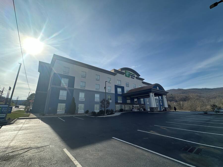 Hotel com amplo estacionamento, entrada coberta e vista desimpedida da paisagem circundante.