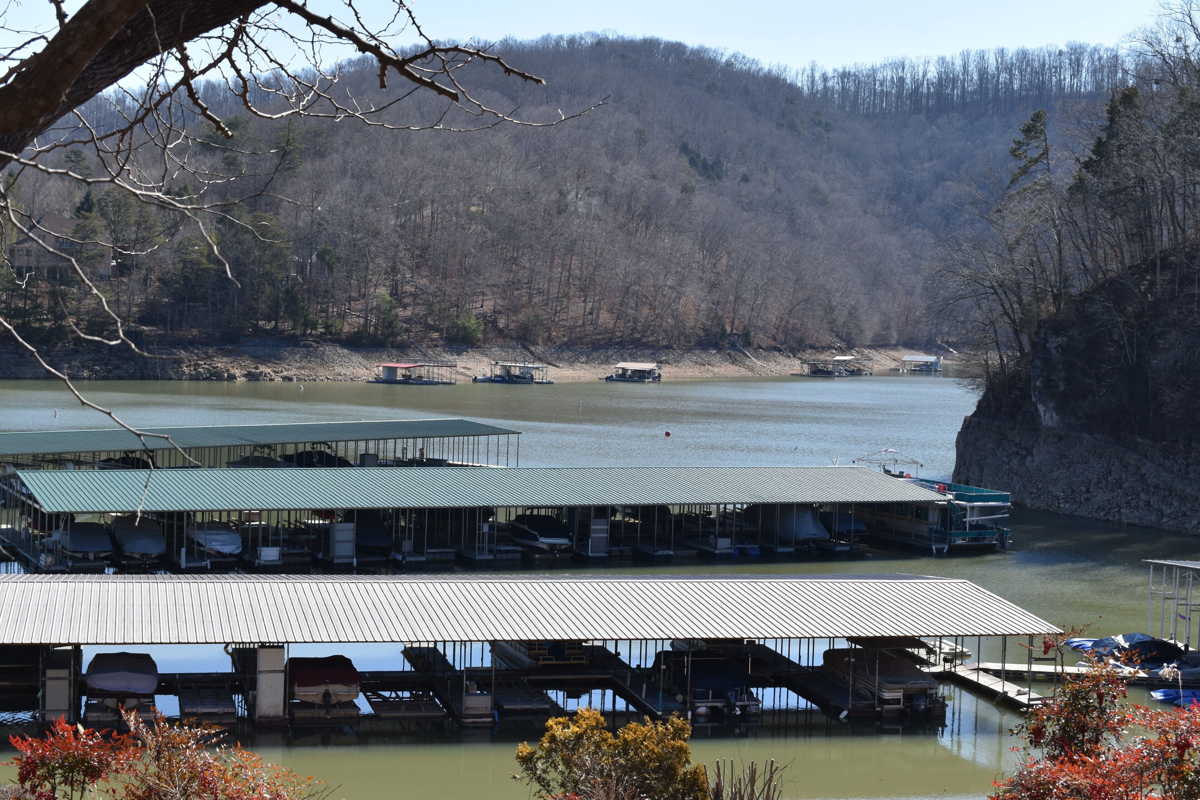 A lakeside dock with covered seating areas and boats.