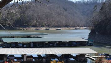 A lakeside dock with covered seating areas and boats.