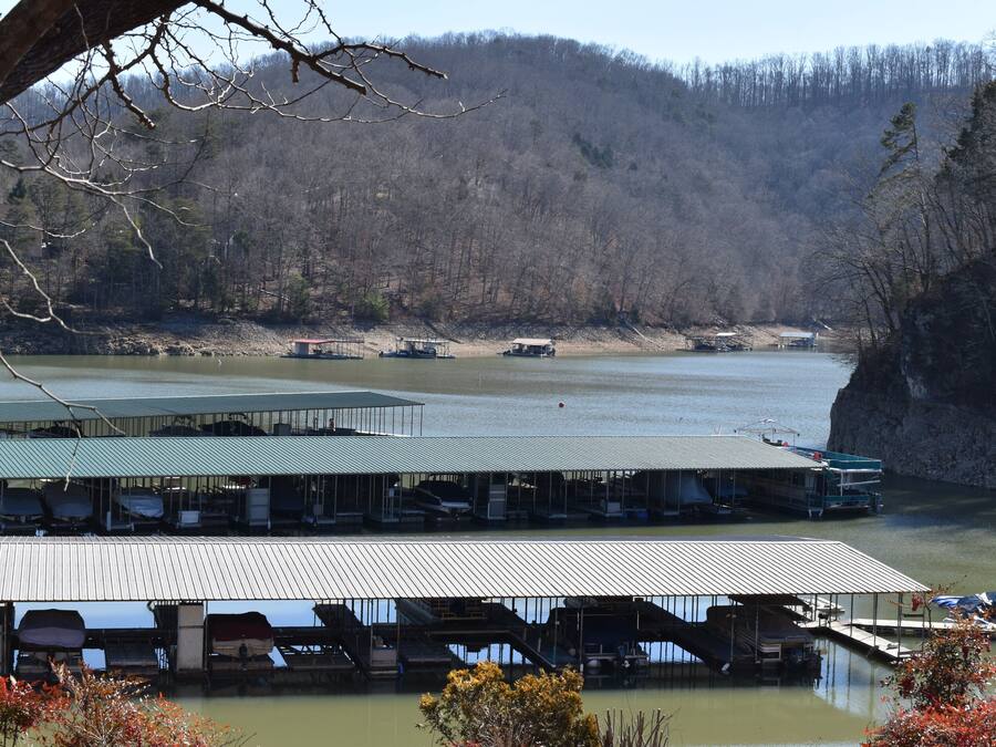 A lakeside dock with covered seating areas and boats.