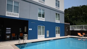 Una piscina al aire libre, tumbonas