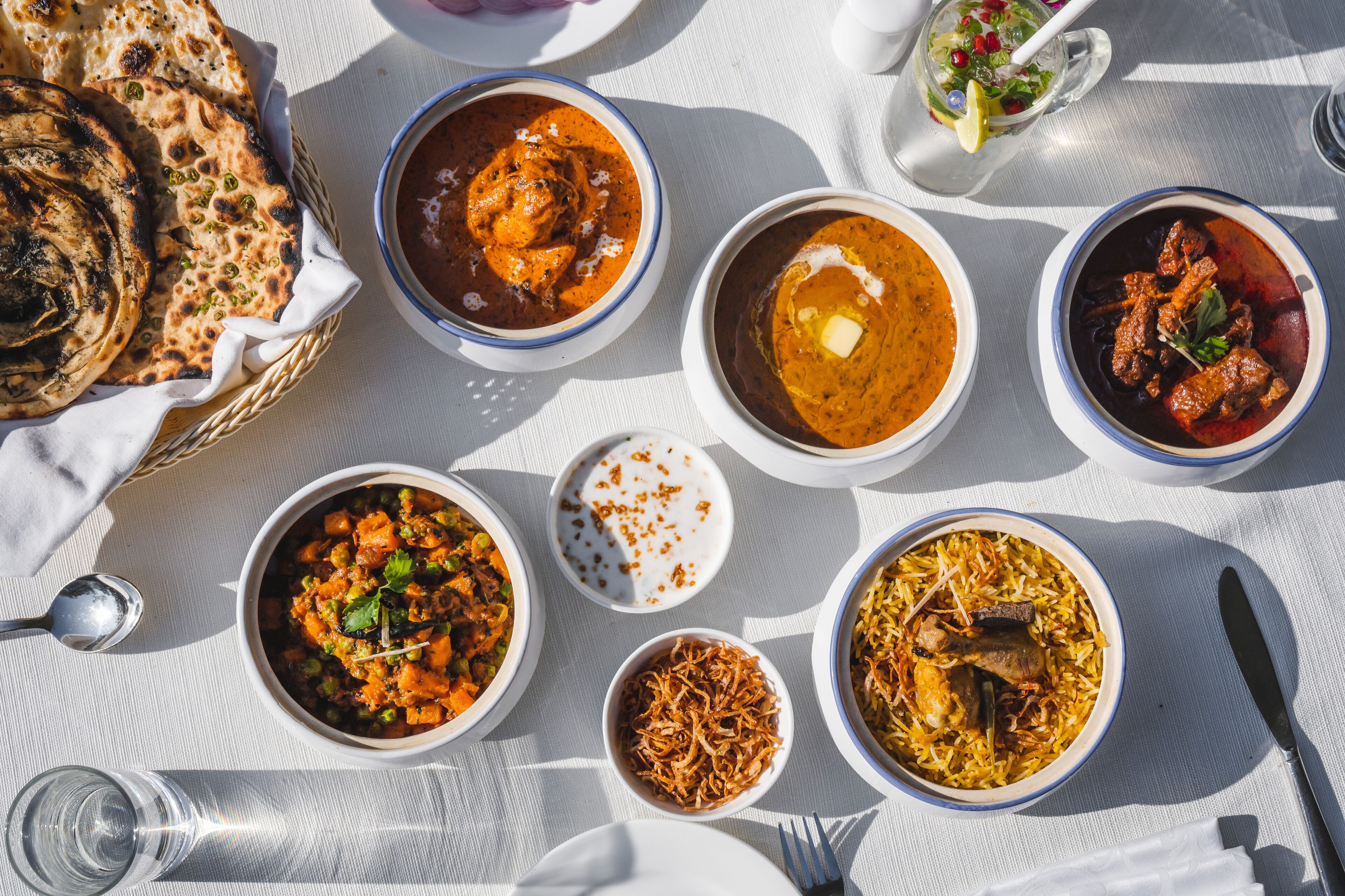 A table with various dishes, including curry, rice, and bread, suggesting a meal setting.