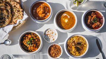 A table with various dishes, including curry, rice, and bread, suggesting a meal setting.