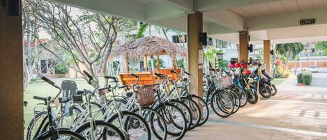 A covered bike parking area with a thatched roof structure and a sign labeled "Lobby".