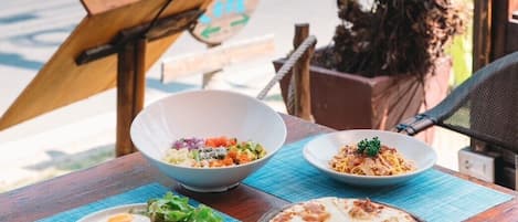 A table with food and a view of the beach.